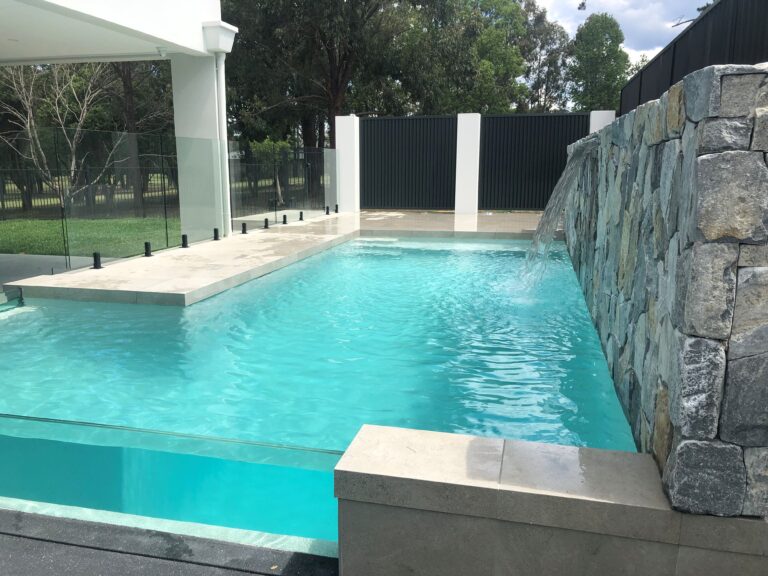 Designer Beadcrete with crazy stone full length feature wall and glass pool windows